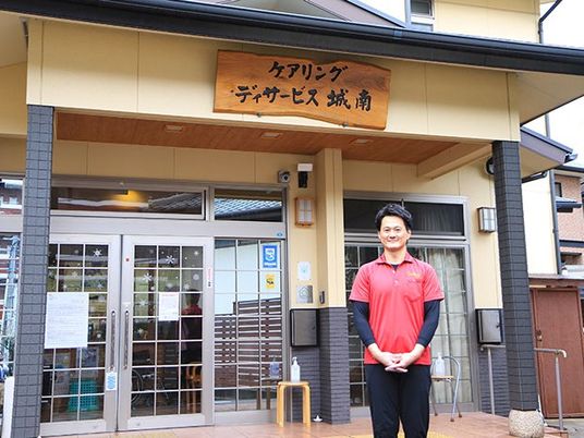 スタッフが立つ施設入口  