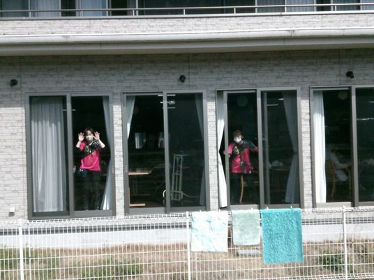 窓辺に立つ職員の建物外観  