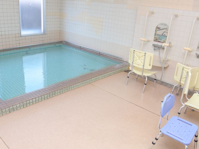 清潔な浴室の全景 大浴場 床に滑りにくい素材を使用した浴室で、手すりや椅子も完備しており、入浴時の安全をサポートしています。