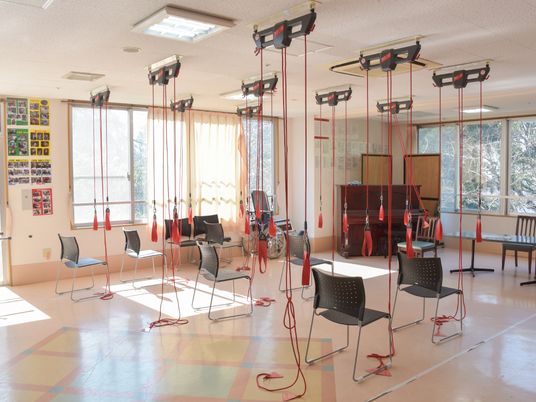 多くの椅子が置かれていて、天井から紐やゴムみたいな物が垂れ下がっており、これらを使ってリハビリしている。