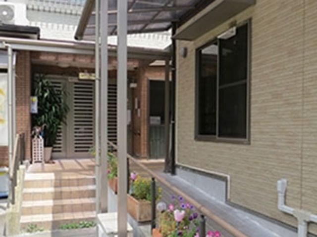 花に囲まれたエントランス エントランス 植物に彩られた入口は、訪れる方々を優しく迎えます。明るく開放的な雰囲気です。