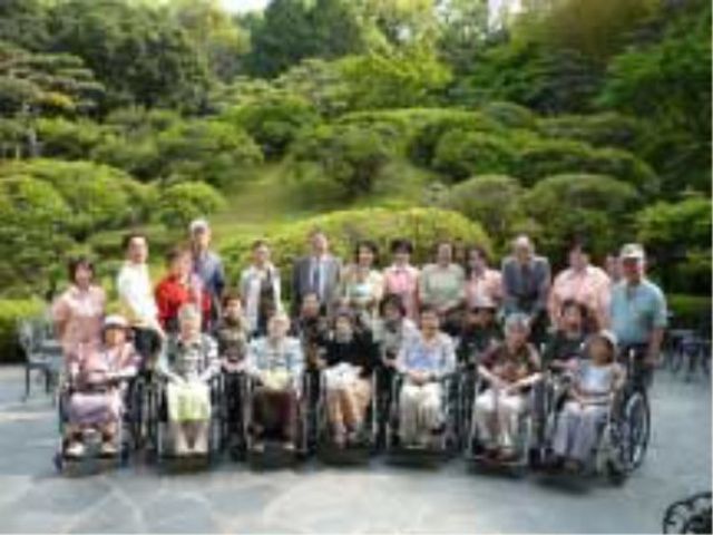 笑顔の集合写真中庭 ご入居者様 緑豊かな中庭に集う笑顔あふれる様子が印象的です。車椅子を使用されている方も一緒に楽しめる広々としたスペースがあります。