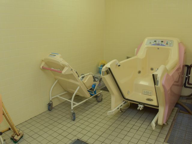 介護用浴槽とシャワーキャリー 入浴室3 広々とした浴室には、安心してご利用いただける機能的な設備が整っています。入浴のサポートも充実しており、快適に過ごせる環境です。