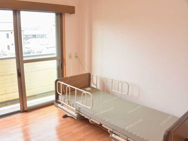 明るく清潔な居室 居室 ゆったりとした居室には、窓から光が差し込み、快適な生活空間を提供しています。ベッドの横には必要な設備が整い、安心してお過ごしいただけます。