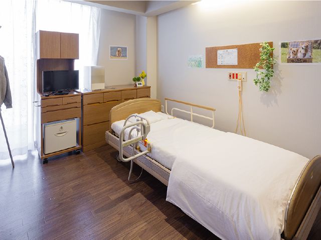 居心地の良い居室 居室 ゆとりある空間の居室はベッドや家具が整い、快適な個人の時間を過ごせそうです。壁面の掲示物や観葉植物が温かな雰囲気を演出しています。
