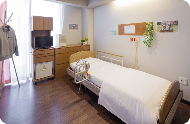 居心地の良い居室 居室 ゆとりある空間の居室はベッドや家具が整い、快適な個人の時間を過ごせそうです。壁面の掲示物や観葉植物が温かな雰囲気を演出しています。