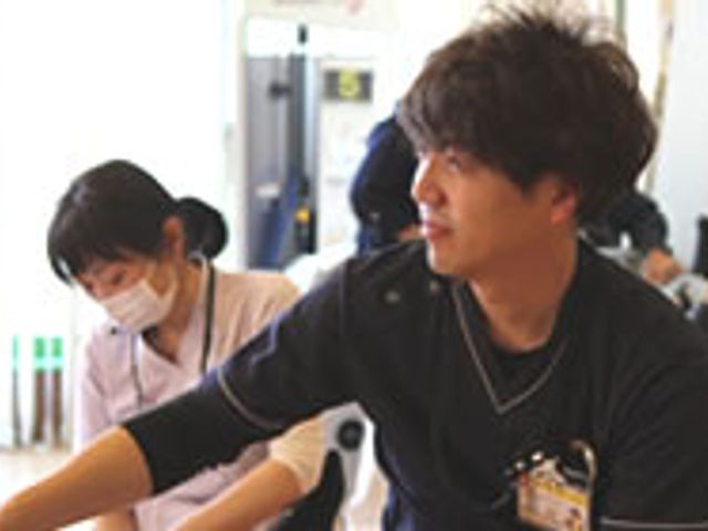笑顔のスタッフと利用者 スタッフイメージ 笑顔で対応するスタッフの姿です。安心して日々を過ごせる環境がここにはあります。