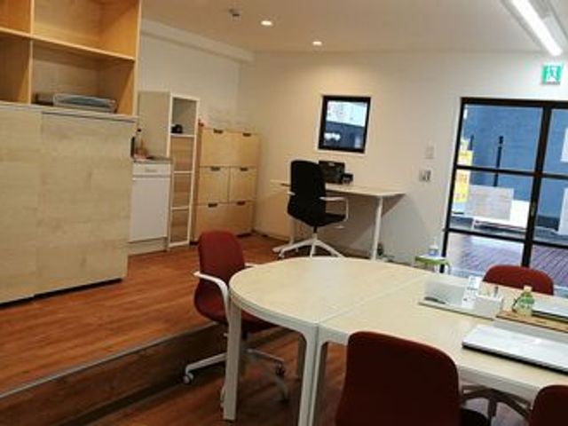 広々としたオフィス風室内 内観 明るい空間で、幅広いカウンターと机が配置され、快適な作業環境を提供しています。