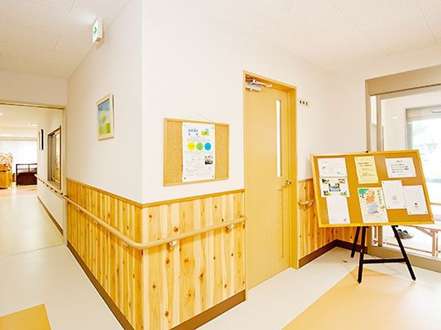廊下の明るい雰囲気 廊下 柔らかな光が差し込む廊下は、手すりがあり安心して歩行できる環境です。掲示物が情報を提供し、ご利用者様の交流の場ともなっています。