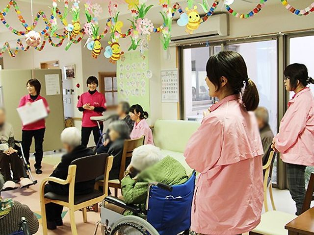 笑顔と交流の空間 ラウンジ 暖かい雰囲気で、スタッフと入居者が交流しています。リラックスして楽しめるエリアです。