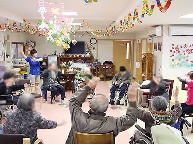 アクティビティ集会室 多目的室 自然光の入る明るい空間で、利用者が楽しんで体を動かしています。交流を深める場として最適です。