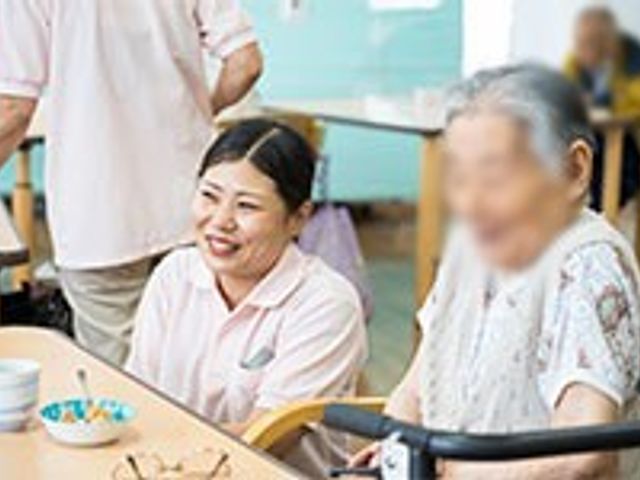 笑顔の交流の様子 リビング 職員が利用者と和やかに交流し、安心して過ごせる空間です。温かみのある雰囲気が魅力です。