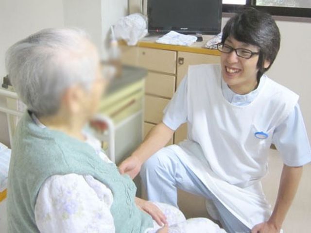 優しい対話の居室 居室 安らぎのある空間で、利用者とスタッフが親しげにコミュニケーションを取っています。