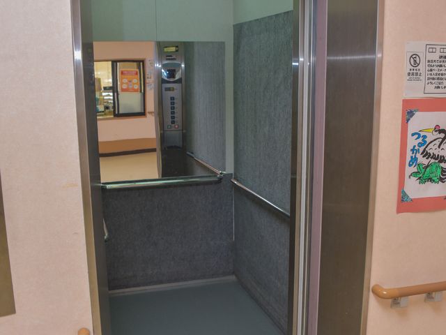 手すり付きエレベーターの入り口 エレベーター 広々とした入口のエレベーターは、手すりが整備されており、安全に配慮されています。車いすの方も安心して利用できる設計になっております。