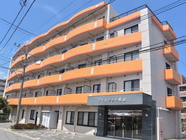 オレンジ色の外壁の施設 施設外観 広々としたエントランスが印象的なモダンな建物です。職場としても清潔感があり、心地よい環境が期待できます。