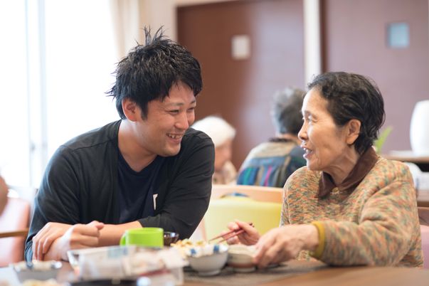 笑顔で会话する二人施設ラウンジ