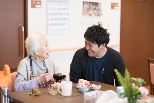 食事中の高齢者とスタッフ