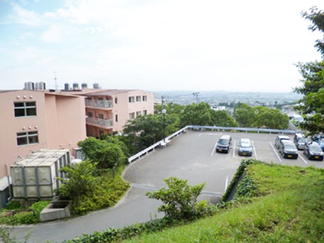 広々とした駐車場 外観 緑に囲まれた空間にある建物の外観です。車でのアクセスもしやすく、駐車場も広々としています。