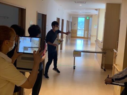 廊下で案内する職員  