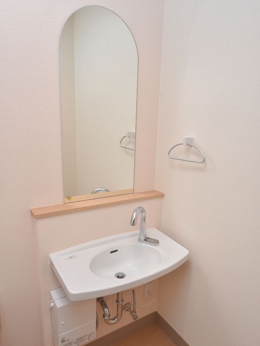 部屋には洗面台が設置されている。大きな縦長の鏡があるので、朝の身支度のときに便利である。ボタンを押すと水がでるので操作が楽である。