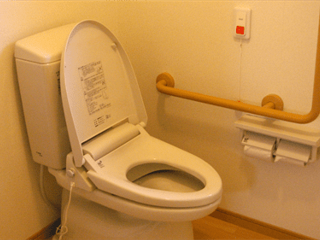 バリアフリートイレ トイレ 持ち手が設置された清潔なトイレです。安全に利用できる工夫がされています。