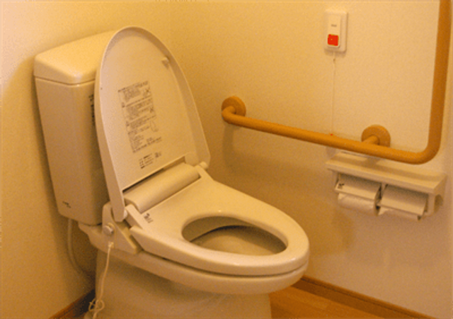 バリアフリートイレ トイレ 持ち手が設置された清潔なトイレです。安全に利用できる工夫がされています。