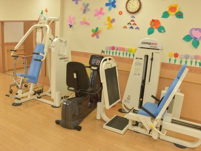 明るい装飾の訓練機器 リハビリの機械 カラフルな飾りが彩る機能訓練室です。先進的な設備で、ご利用者のリハビリをサポートしています。