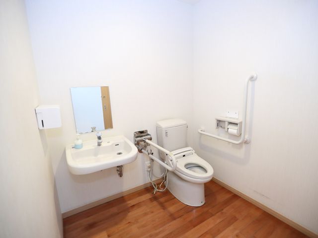 バリアフリー設計のトイレ トイレ 手すり付きで安全性に配慮された清潔なトイレです。使いやすさを鑑みたシンプルなデザインで、快適な日々を支えます。
