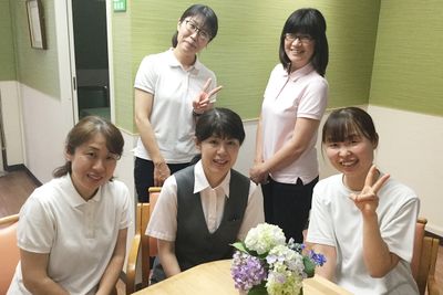 笑顔のスタッフと花のテーブル