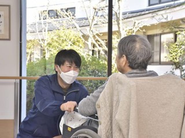 優しい相談の様子居室 居室 笑顔で親身に寄り添うスタッフが、利用者の方と穏やかに会話を楽しんでいます。