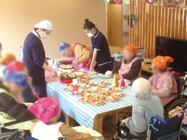 食事を楽しむ風景 リビング みなさんがテーブルを囲んで、楽しく食事の時間を過ごしています。賑やかな雰囲気です。