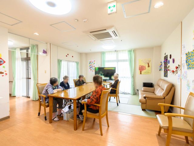 利用者の憩いの共有スペース 共有スペース 温かみのあるラウンジでは、利用者が会話を楽しんだり、テレビを鑑賞する風景が見られます。適度な広さがあり、快適に過ごすことができそうです。