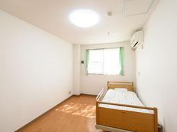 明るい室内とベッドのある居室