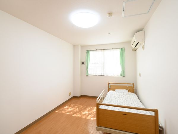 明るい室内とベッドのある居室