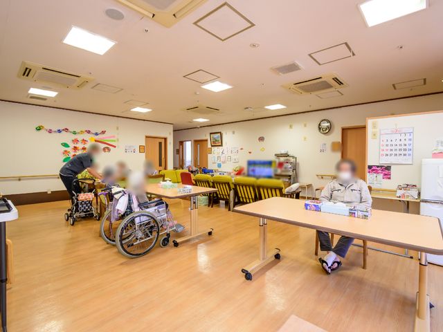 広々とした共有スペース リビング 広々としたダイニングでは、入居者が食事や憩いの時間を過ごしています。利用者対応に真摯に取り組むスタッフの姿が見受けられます。