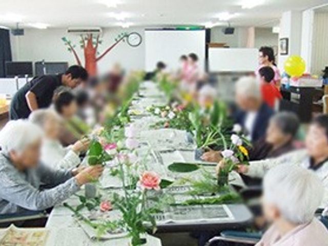 活動を楽しむ空間 多目的室 幅広い年齢層が集まり、花を手に楽しく交流している場です。リラックスした時間を過ごせます。