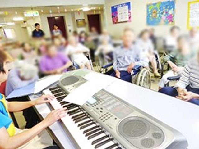 音楽を楽しむラウンジ ラウンジ 居住者が集まり、音楽を楽しむ和やかな場です。スタッフがキーボードを演奏しています。