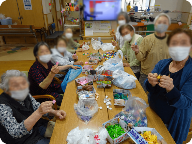 活動を楽しむ様子の室内 多目的室 明るい多目的室で、みんなで手作業を楽しんでいる様子です。リラックスした雰囲気が特徴です。