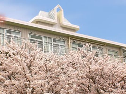 桜越しの施設外観  