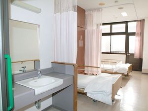 ベッドと洗面台のある居室  