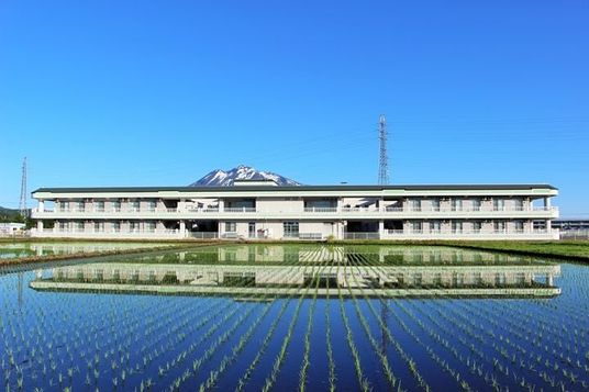 背景に山が見える外観