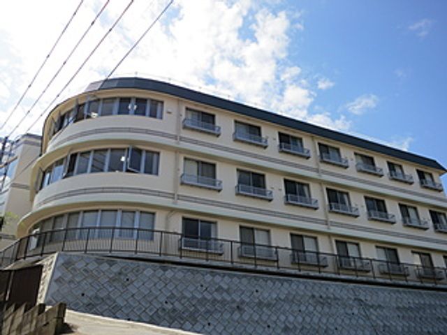 曲線的な形状の建物外観 外観 曲線的なデザインの建物で、明るい空を背景にしています。爽やかな印象です。