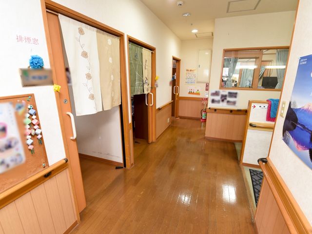 廊下の明るい風景 廊下 温かみのある木目調の廊下は、明るく広々としており、掲示物や飾りが活気のある雰囲気を演出しています。ゆったりとした通路は、日々の快適な移動を支えます。