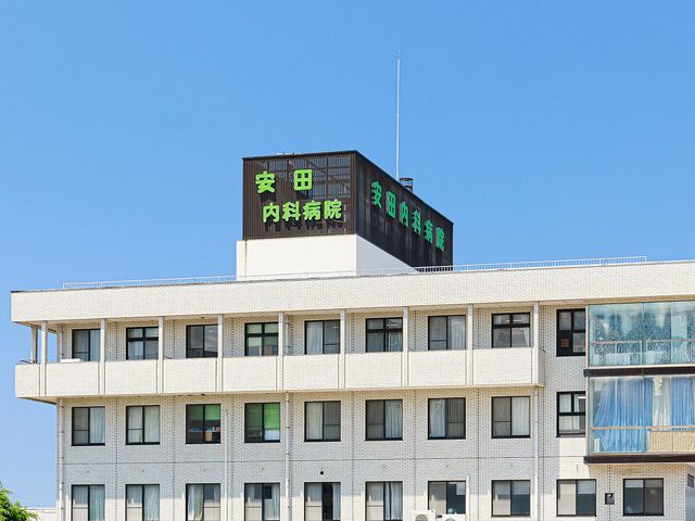 病院の外観 外観   白い外壁の建物に、緑色の大きな看板が目立ちます。青空の下で、落ち着いた印象の建物です。