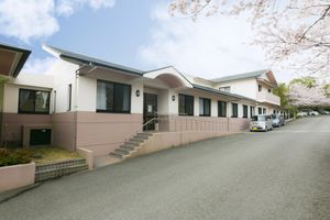 桜に囲まれた建物の外観  