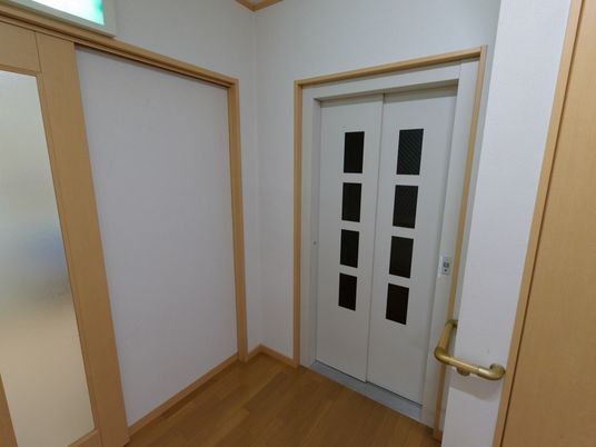 白い扉と手すりの廊下