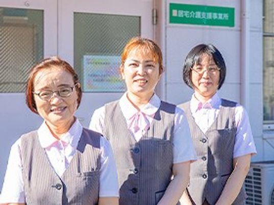 笑顔のスタッフ三人が並ぶ玄関前  