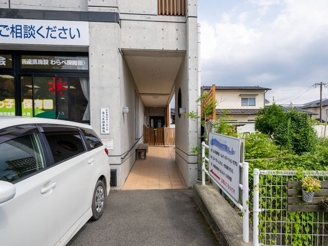 エントランスの外観 イベント 清潔感のある建物入口から見える、ゆったりとした通路です。働くスタッフや訪れる方々が快適に過ごせるように配慮されています。