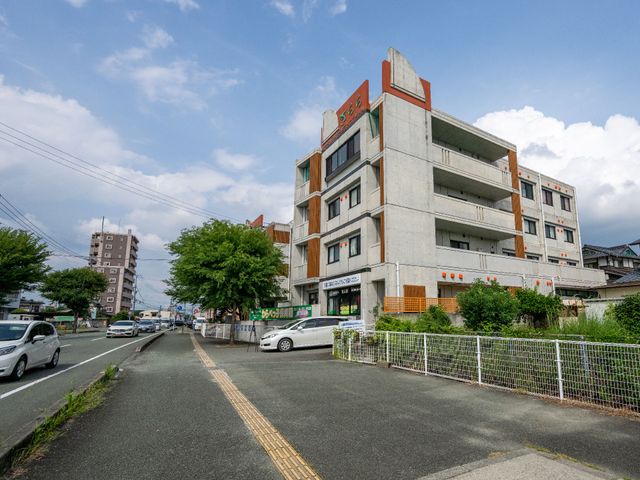 広々とした道路沿い建物 外観 道路に面した落ち着いた色合いの建物です。通りからのアクセスも良好で、周囲の環境も清潔感があります。