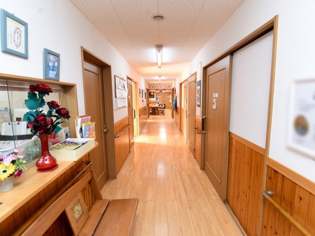 木目調の温かい廊下 廊下 木の暖かみを感じる廊下です。ゆったりとした通路で、皆様の快適な移動を助けます。